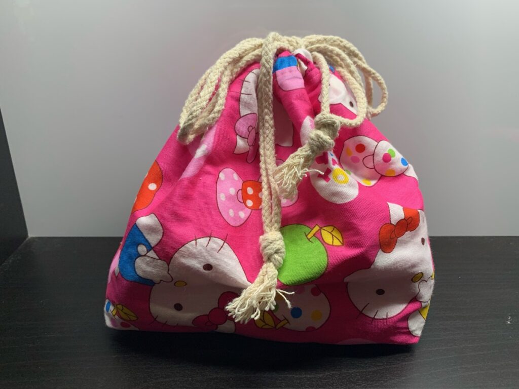Bolsa de tela rosa de Hello Kitty para guardar una plancha pequeña, cerrada con cordones