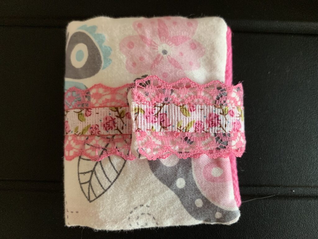 Botiquín para el bolso hecho a mano con tela estampada y cierre de snap rosa.