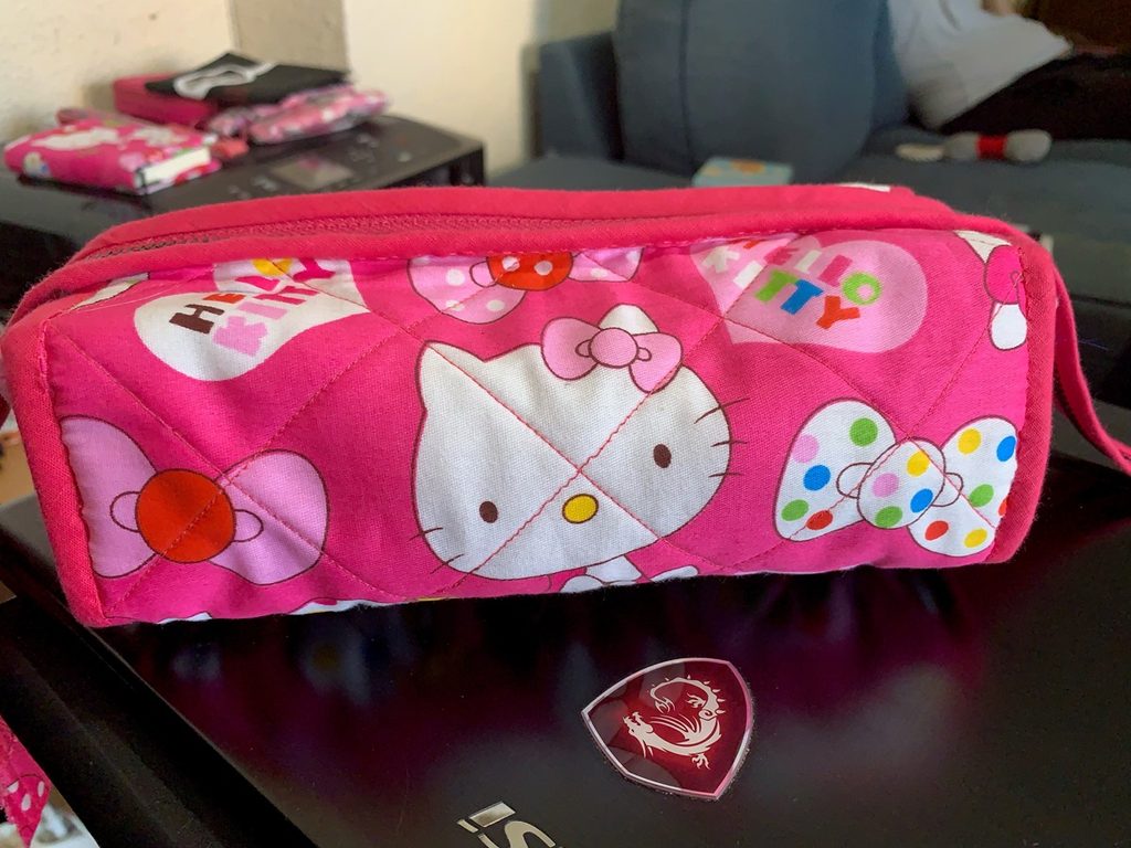 Costurero de viaje acolchado hecho a mano con tela rosa de Hello Kitty y cierre de cremallera.