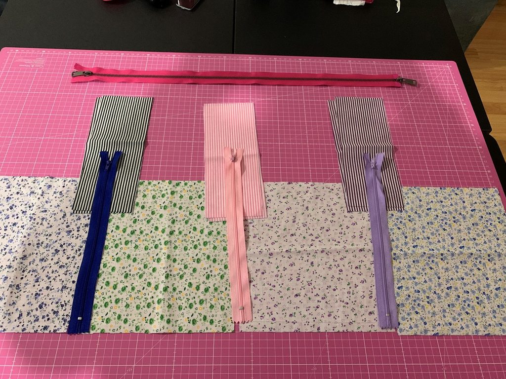 Piezas de tela y cremalleras preparadas sobre una base de corte durante la confección del costurero de viaje.
